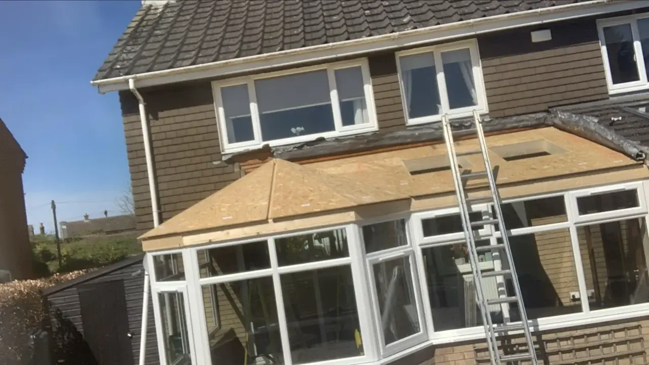 Conservatory warm roof conversion during construction with timber roof decking and rooflight openings. By Norfolk Exterior Solutions.